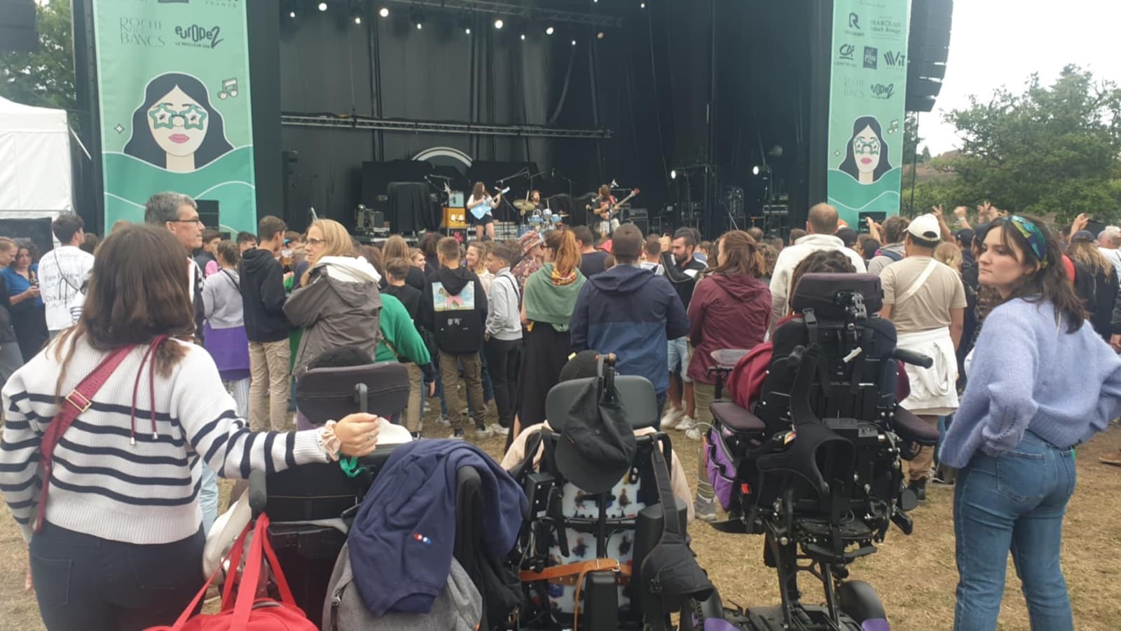 Jeunes vacanciers en fauteuil roulant assistant à un concert en plein air