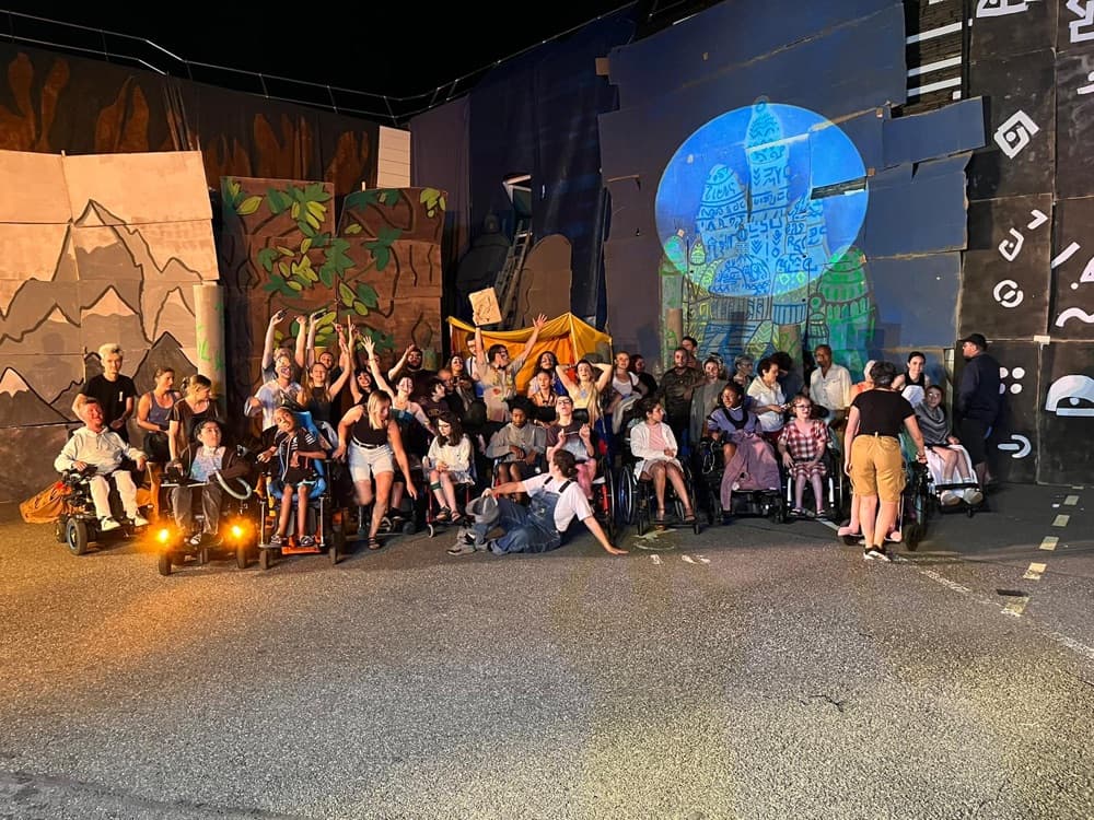 Jeunes valides et en situation de handicap réunis devant les décors illuminés du spectacle